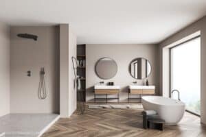 panoramic bathroom interior with a shower cabin, on trend round mirrors with two vanities, an oval white ceramic bathtub