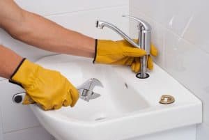 Plumber installs a new faucet for a sink